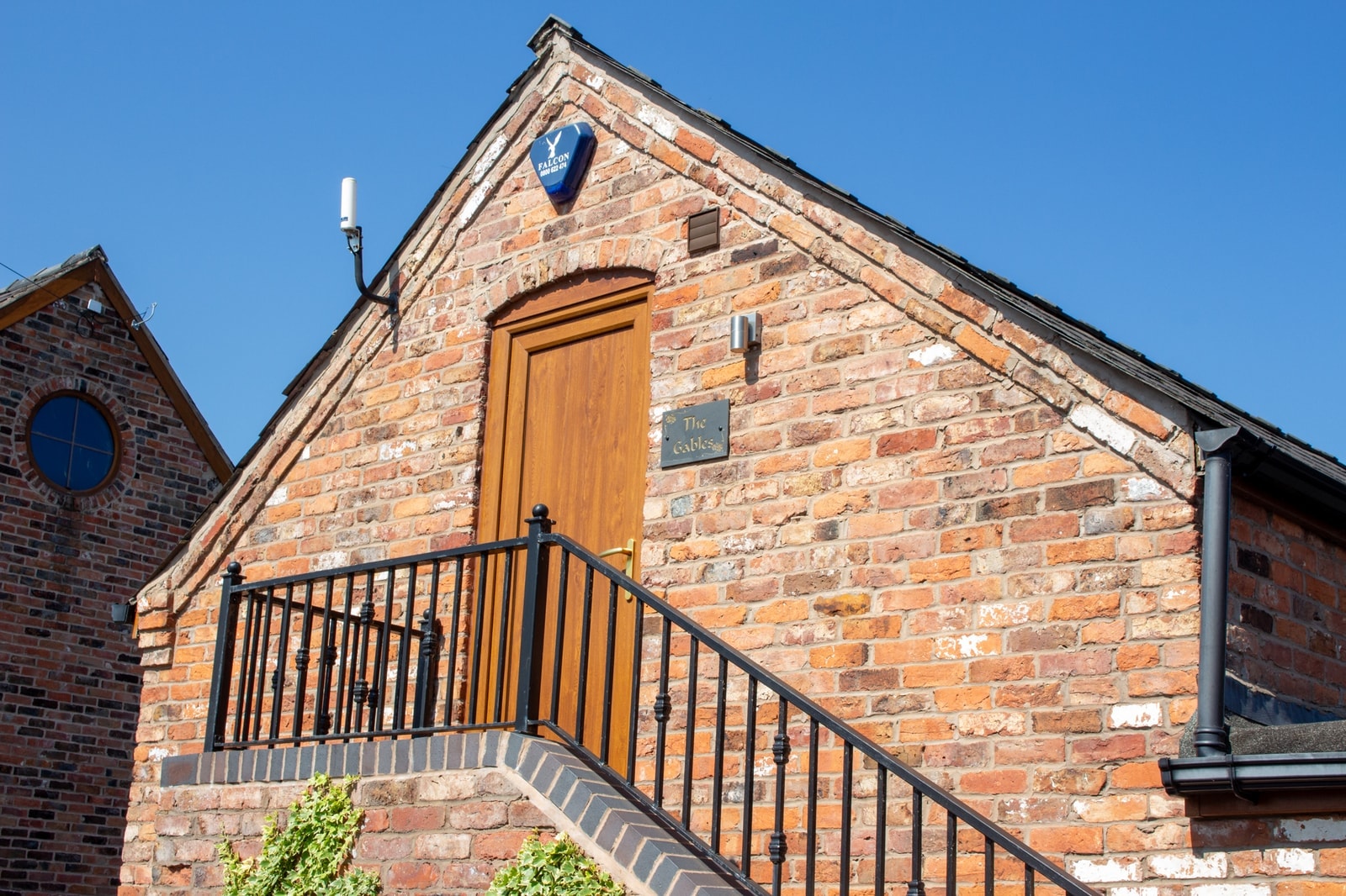 The barn gable, its oak door reached by external steps and an iron railing