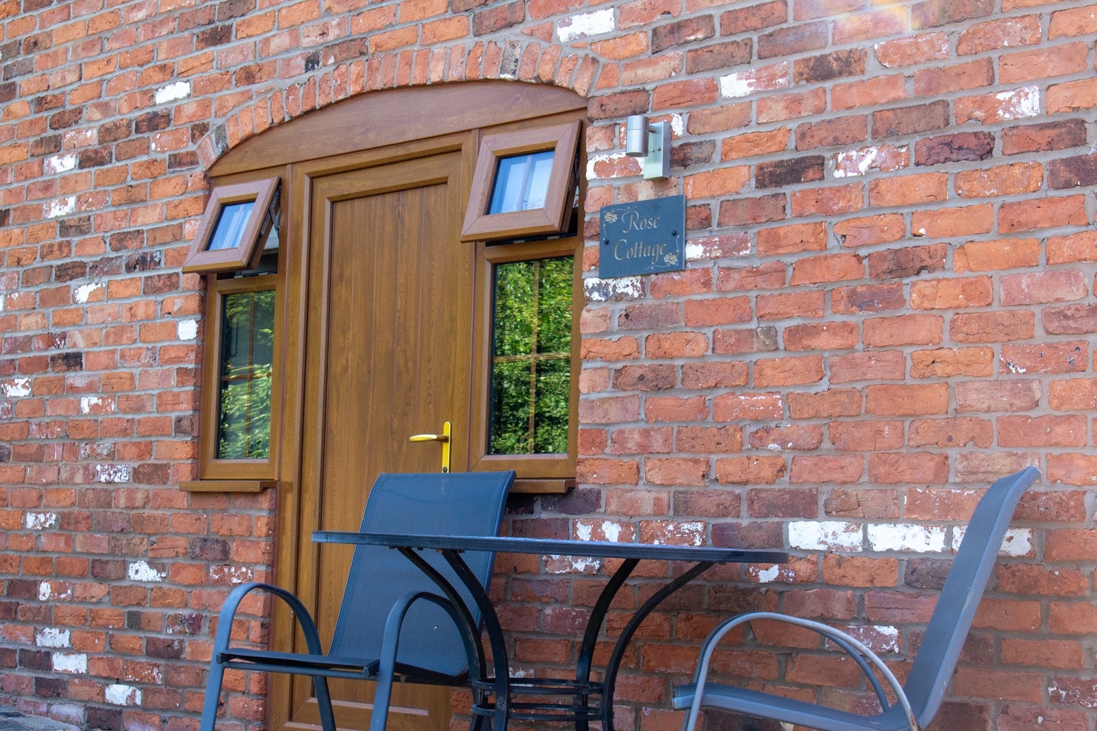 A bistro table and chairs set outside one of the cottage doors