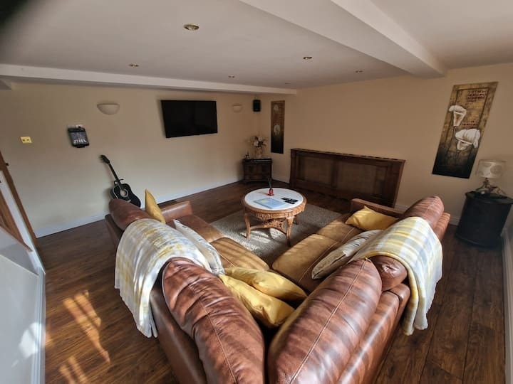 The living room, with leather sofas around a low table under a beamed ceiling