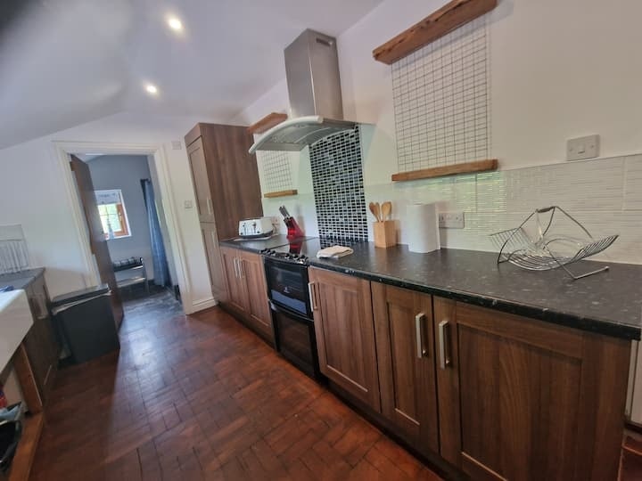 The kitchen in dark wood, with granite worktops and an extractor over the range