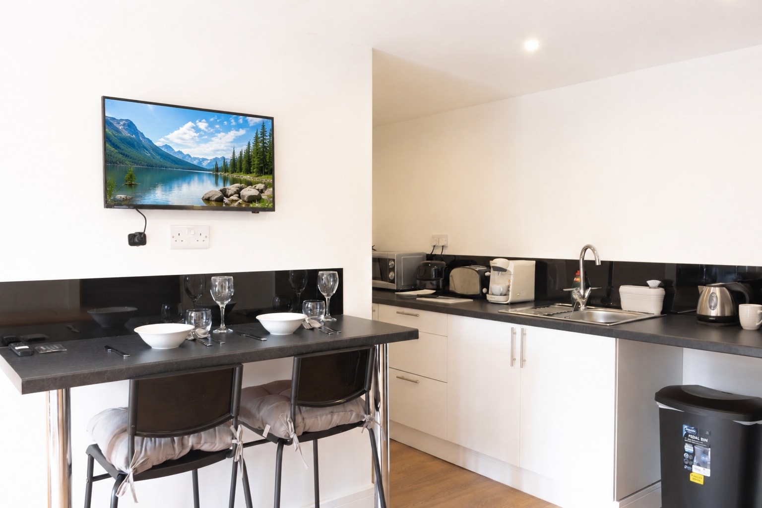 The open kitchen and breakfast bar, with a wall-mounted television