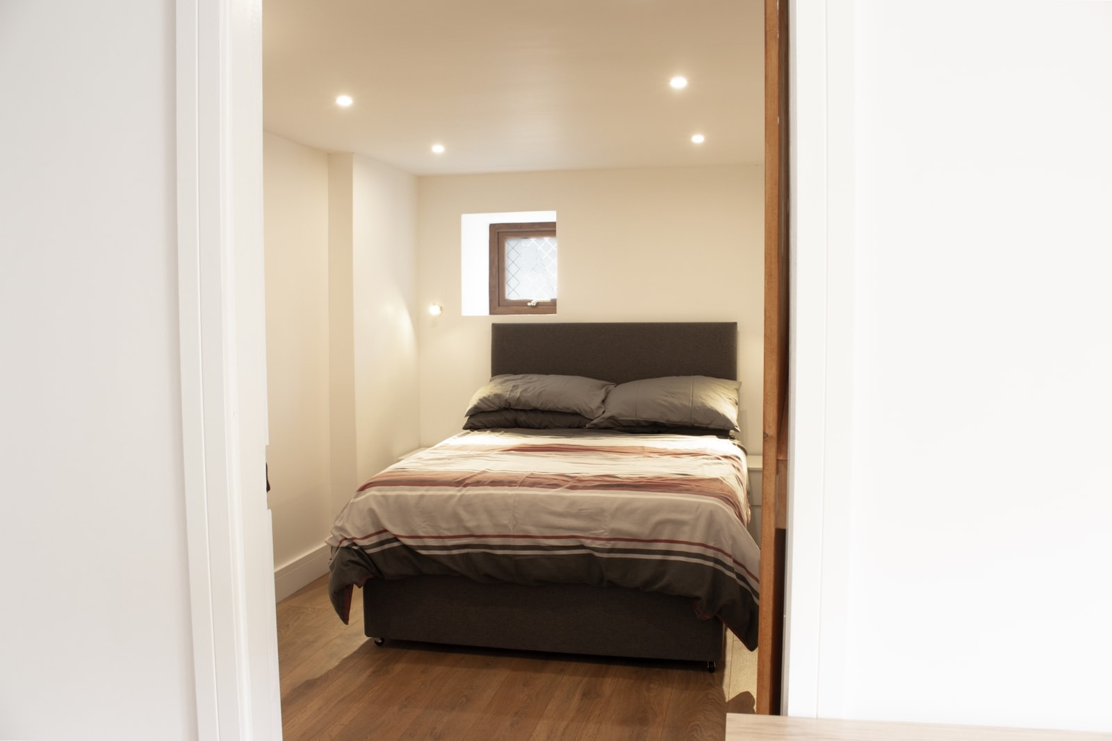 The second double bedroom, made up and softly lit