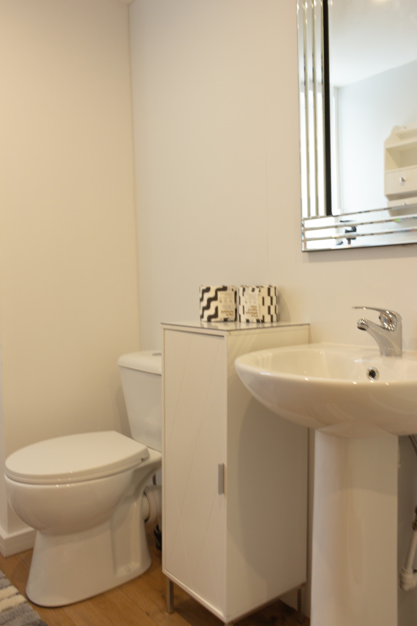 The bathroom, with basin, mirror and heated towel rail