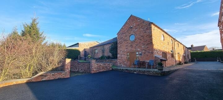 Oak Cottage from the courtyard, brick gable against a clear sky