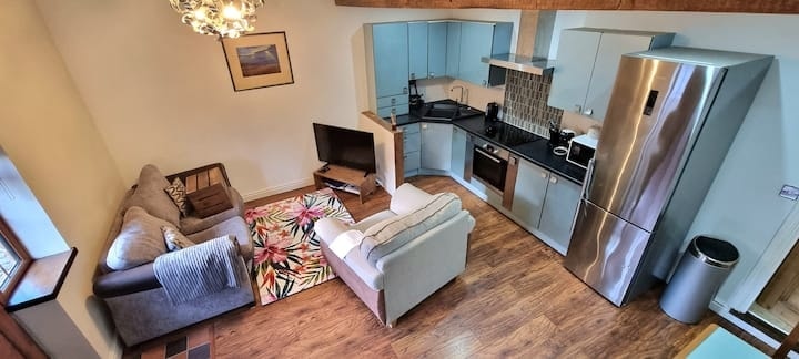 The open-plan kitchen and living space, with sofas facing the television