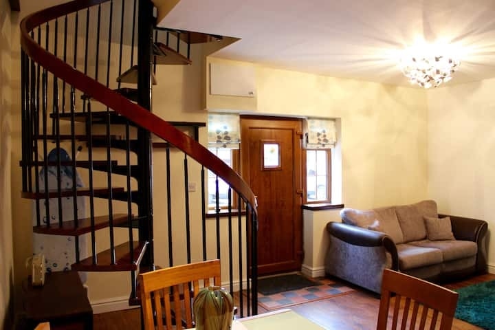 The spiral staircase rising from the living room