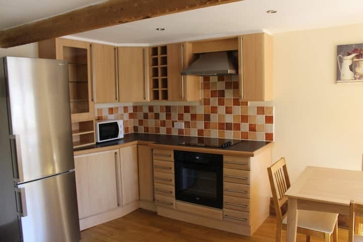 The kitchen in light wood, with a tiled splashback and oven