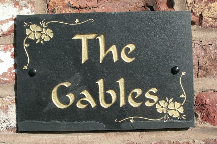 The painted slate The Gables nameplate on brick
