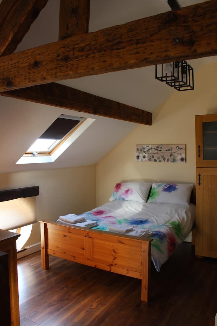 The bed set beneath the skylight and sloping ceiling