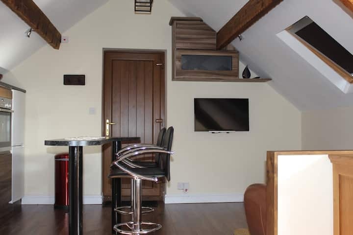 The breakfast bar and stools beside the television
